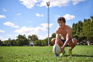 Image showing Man, rugby ball and ready to kick on field with thinking, aim and target for challenge, training and fitness. Athlete, vision and prepare for sports, game or workout on grass field with wellness