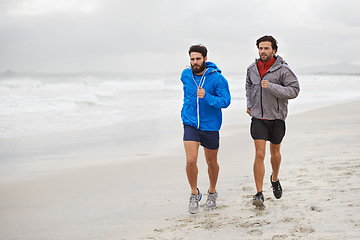 Image showing Male athletes, running and workout on beach, sand and fitness for wellness and gym wear on coast travel. Men, jog and training for seaside, health and outdoor for sport and exercise together