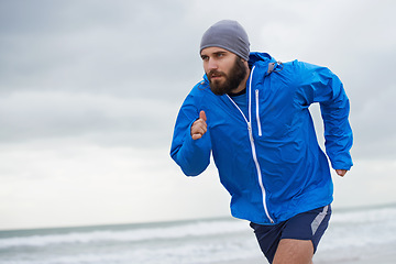 Image showing Beach, man or running for exercise, wellness or training outdoor in nature to workout for body health. Ocean, athlete or person jog for fitness, cardio or sport with energy at sea in winter on mockup