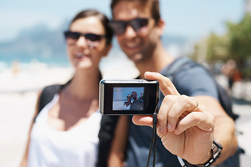 Image showing Couple, beach and digital camera for selfie on holiday with smile, sunglasses and outdoor for memory in summer. People, man and woman with photography by sea for journey, vacation and screen in Italy