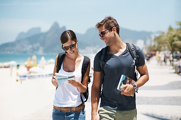 Image showing Couple, tourist and beach with map for guide on holiday, tour and travel for summer in Rio de Janeiro. Relationship, vacation and happy in seaside for trip in adventure, together and smile for break