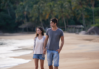 Image showing Holding hands, walking and couple on beach for vacation, adventure or holiday for tropical travel. Nature, love and young man and woman by ocean or sea for romantic date on weekend island trip.