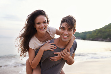 Image showing Couple, beach and piggyback with sea, smile and nature with travel and date for relationship. Man, woman and indonesia ocean for adventure, vacation and tropical holiday with sunshine and portrait