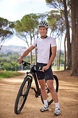 Image showing Portrait, cycling and break with man in forest for off road fitness, sports or outdoor cardio hobby. Bike, nature and training with confident young athlete sitting on bicycle to relax in woods