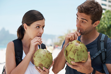 Image showing Couple, coconut and drink at beach in summer for vacation with milk, cocktail and juice on journey. People, man and woman with thinking, review and fruit for water, hydration and detox with nutrition