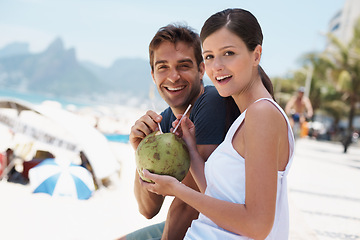 Image showing Couple, coconut and drink at beach with smile for vacation with milk, cocktail and juice in portrait. People, man and woman with sunshine, review and fruit for water, happy and detox with nutrition