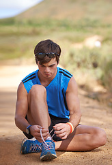 Image showing Tie, runner or man with shoe lace for fitness training, walking exercise or workout on path or sand. Running, wellness or male sports athlete with footwear ready to start outdoor hiking in nature