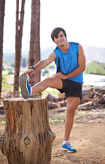 Image showing Nature, portrait or runner stretching legs for fitness training, wellness or exercise outdoors on tree log. Man, mobility and healthy male athlete in body warm up to start running or cardio workout