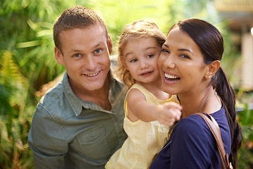 Image showing Happy family, portrait and child pointing at zoo with hug for love, care or support in nature. Father, mother and young little girl showing direction, guide or exhibit for fun exploring together