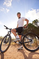 Image showing Cyclist, man and bicycle ride in outdoors, hill and mountain biking in countryside. Male person, freedom and cardio for fitness or exercise, hobby and sports for adventure and off road by blue sky