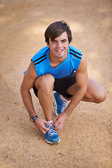 Image showing Portrait, runner or happy man in nature to tie shoe lace for fitness training, walking exercise or workout on path. Running, sports or athlete with footwear ready to start outdoor hiking for travel