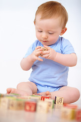 Image showing Boy, baby and playing with wooden blocks or toys for childhood development on a gray studio background. Little toddler, cute or adorable child learning shapes, letters or building on mockup space