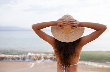 Image showing Hat, hands up or woman at sea for travel adventure to relax on holiday vacation in summer or Bali. Back, breathe or female person at beach with open arms in nature for fresh air, freedom or gratitude