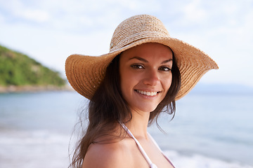 Image showing Beach, happy and portrait of woman for travel on tropical vacation, adventure or holiday. Smile, nature and female person with hat by ocean or sea water on outdoor summer weekend trip by island.