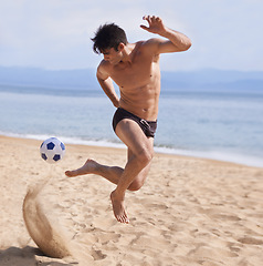 Image showing Male athlete, soccer and sand on beach, exercise and training for cardio sports. Bathing suit, football and athletic man on holiday and fun on shoreline, summer and workout and outdoor on vacation