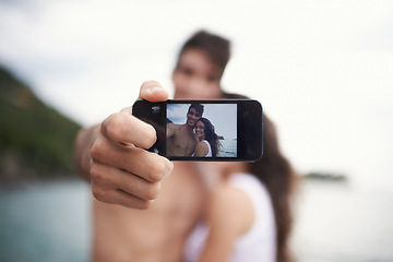 Image showing Phone screen, selfie and happy couple outdoor for vacation, holiday and travel together at ocean. Face, woman and man taking pictures at sea for love, smile or memory in summer by water in nature