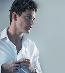 Image showing Thinking, shirt and business man getting ready in studio isolated on gray background for start of career. Face, fashion and button with serious young employee dressing in outfit for interview