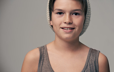 Image showing Boy, child and beanie in studio for portrait with smile, teenager or edgy for fashion by background. Kid, model and hat for trendy style, happy and pride for clothes with confidence in hipster outfit