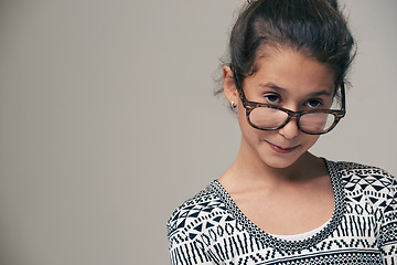 Image showing Girl, child and glasses in studio with space, thinking and mock up for style, vision and eye care by background. Kid, model and frame with eyesight, wellness and nerd for optometry in childhood