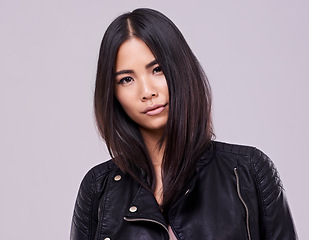 Image showing Asian woman and fashion with jacket in confidence on studio, style and casual in grey background. Portrait, female person and trendy with leather top, clothes and outfit for streetwear and gen z
