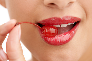 Image showing Woman, mouth and bite with cherry, red lipstick or cosmetics for nutrition on a white studio background. Closeup of person, teeth or natural organic fruit with makeup or gloss for diet, fiber or glow