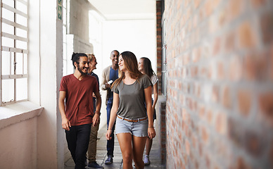 Image showing University, walking and students in a lobby, conversation and speaking with humor or education. Group, men or women in a hallway with discussion or learning with knowledge or college with scholarship