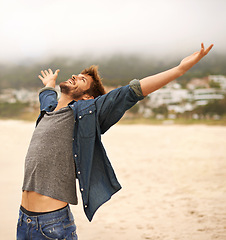 Image showing Happy man, beach and freedom with hands out for travel, adventure or outdoor sightseeing in nature. Excited male person with smile in satisfaction or happiness for holiday weekend on the ocean coast