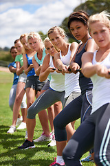 Image showing Group, women and friends in tug of war with team building, strong and balance for challenge on field. People, exercise and training with rope for games, contest or competition with muscle on grass