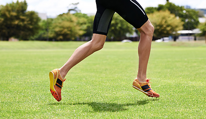 Image showing Athlete, run and outdoor for race, legs and activewear in workout and training for wellness and cropped jog. Cardio, wellbeing and sport for exercise, health and fitness on grass for summer shoes