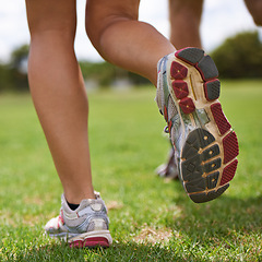 Image showing People, running shoes and closeup on grass for exercise together in summer for health, wellness or training. Person, runner and partner with feet on field for workout, fitness and speed with sneakers