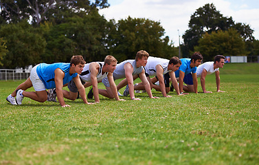 Image showing Team, running and start of training in outdoors, sprint and practice on sports field for race. People, athletes and cardio challenge on grass for workout, performance and ready by starting line