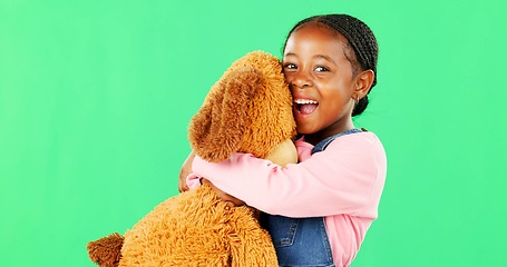 Image showing Green screen, love and a black girl hugging her teddy bear in studio in excitement or comfort. Portrait, happy and embrace with an adorable little female child holding her stuffed animal on chromakey