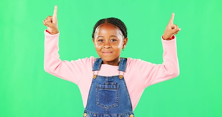 Image showing Children, pointing and a black girl on a green screen background in studio for marketing a product. Kids, portrait and advertising with a cute little female child showing space on chromakey mockup