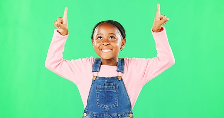 Image showing Kids, pointing and a black girl on a green screen background in studio for marketing a product. Children, portrait and advertising with a cute little female child showing space on chromakey mockup