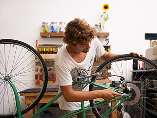 Image showing Small business, startup and bike repair with man mechanic in workshop for service or maintenance. Entrepreneur, handyman or technician working on bicycle to fix chain, gear and wheel for occupation