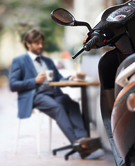 Image showing Scooter, city and businessman at outdoor restaurant for remote work on laptop or transport in morning. Travel, vehicle and street coffee shop with corporate person in suit working at sidewalk cafe