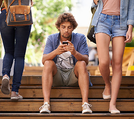 Image showing Phone, school and student man on stairs of university or college campus for social media break. Education, scholarship and study with young person typing mobile text message on steps at recess