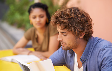 Image showing Face, education and student man reading on college or university campus for learning and study. Book, scholarship and pupil with young person outdoor for research on break or recess at school