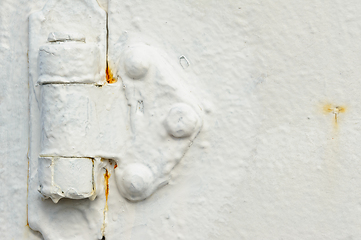 Image showing Close-up of peeling white paint on an aged metal surface showing