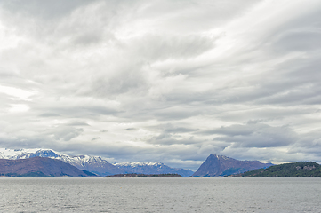 Image showing Majestic snow-capped mountains overlooking the serene sea under 