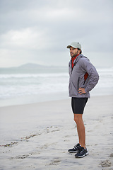 Image showing Fitness, break and man thinking at a beach after training, running or winter morning cardio in nature. Workout, recovery and male runner at the sea for sports rest, breathing or body wellness routine