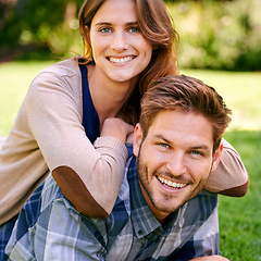 Image showing Happy, couple and smile on lawn together, laying and summer portrait to relax in natural environment. Love, family time for caring on holiday and relationship growth, attractive and garden date