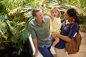 Image showing Happy family, child and pointing at zoo with tourist for sightseeing, travel or tour on trip. Father, mother and little girl showing direction, guide or exhibit to explore together in outdoor nature