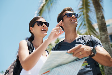 Image showing Travel, map and couple on vacation together for adventure, holiday and sightseeing in outdoor for summer. Tourist, smiling and pointing at location for backpacking and trip on journey in sunshine