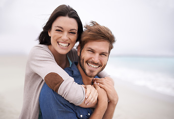 Image showing Couple, portrait and hug with happiness at beach for holiday, vacation and honeymoon with love, relationship and outdoor on seascape. Newlyweds, lovers and people excited for marriage together
