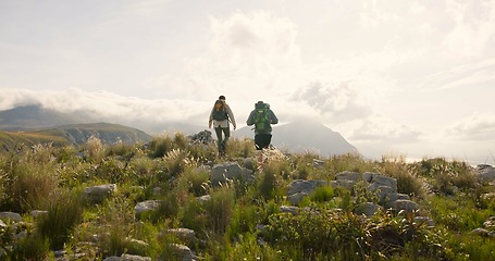 Image showing Back of couple hiking, walking on mountains and travel for adventure, wellness and health in nature together. Sports people with backpack for trekking on rocks, green hill and eco friendly journey