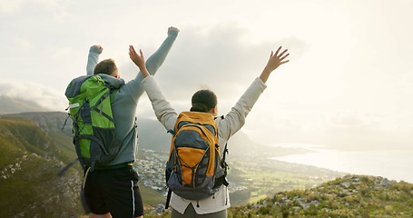 Image showing Couple, mountain top and freedom or celebration of hiking goals, travel and trekking adventure in nature. Back of happy people or winner with arms up for success or excited on a cliff and cityscape