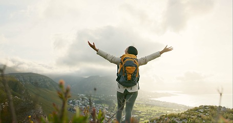 Image showing Woman, mountain top and freedom or success for hiking goals, travel or trekking adventure in nature. Back of hiker or winner in backpack and arms up for celebration, achievement or excited on a cliff