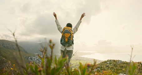 Image showing Person, mountain top and freedom or celebration of hiking goals, travel or trekking adventure in nature. Back of hiker or winner in backpack and arms up for success, achievement or excited on a cliff