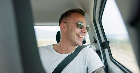 Image showing Happy man, car and sunglasses on road trip in backseat for travel, journey or adventure in the countryside. Male person smile in joy looking out vehicle window for natural scenery, holiday or weekend
